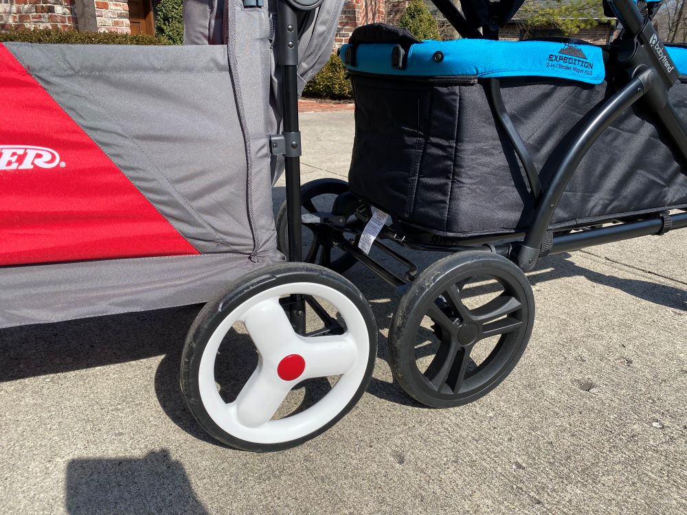 the rear wheels of the Radio Flyer Discovery Stroll 'N Wagon side by side with the Baby Trend Expedition 2-in-1 Wagon. Radio Flyer wagon wheels are larger
