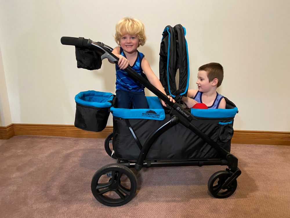 two kids in the baby trend expedition wagon