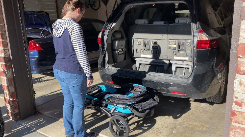 a mom lifting and stowing the baby trend expedition stroller van into a minivan