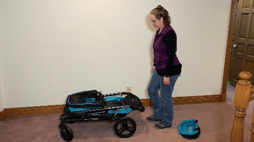 a mom folding the baby trend expedition 2-in-1 stroller wagon