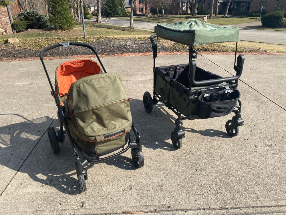 evenflo pivot xplore stroller wagon sitting next to the jeep wrangler wagon outside