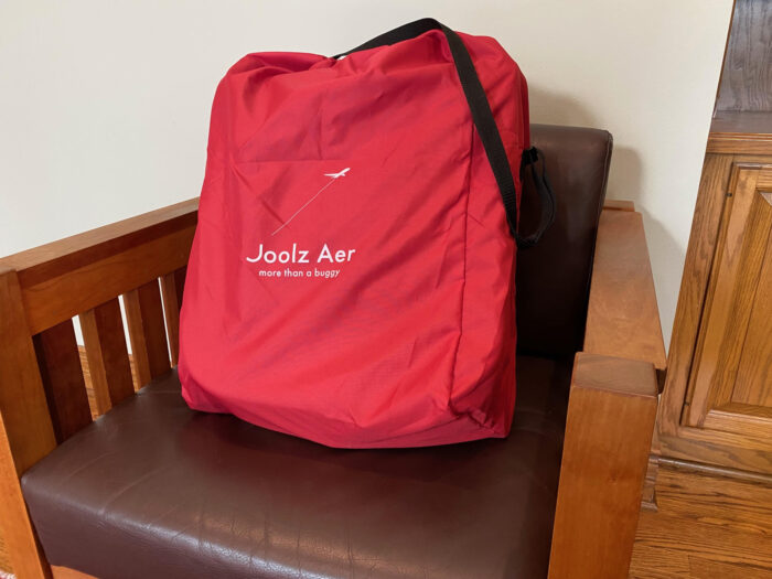 Joolz Aer red travel bag with long black handle strap