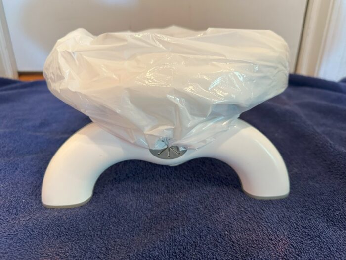 Side view of OXO Tot potty chair, showing where the bag flaps insert into the chair legs for secuirty