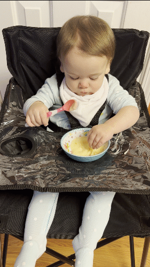 GIF of our one-year-old test subject helping us make a mess on the Ciao Baby high chair