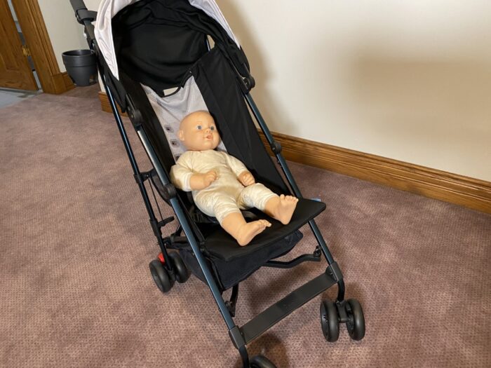 doll in the uppababy g-lite in a reclined position