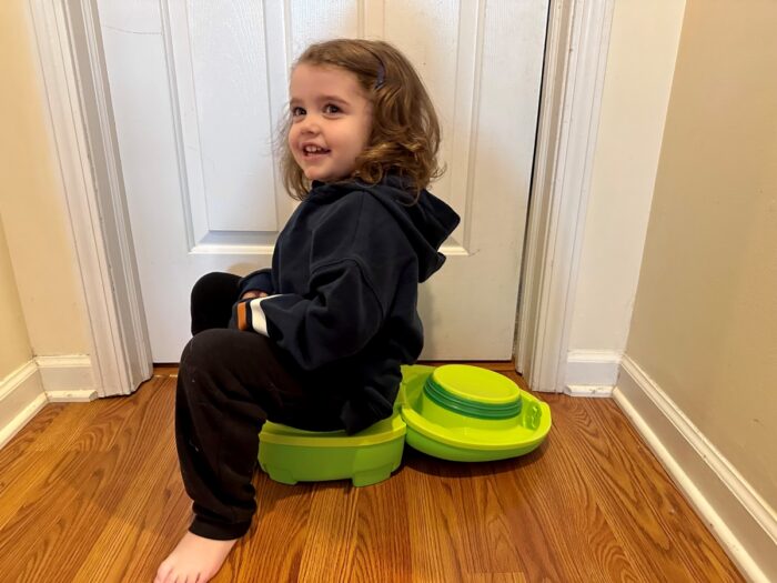 Side view of a child sitting on the My Carry Potty