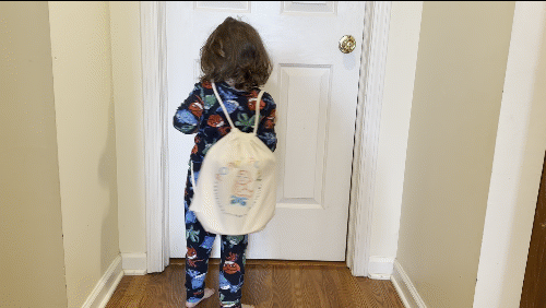 GIF of child wearing the Poppy Potty carry bag and twirling 
