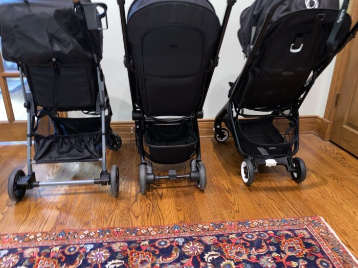 Left to right: sitting side by side the Zoe Tour+, Joolz AER, Bugaboo Butterfly showing storage baskets and backs of strollers.