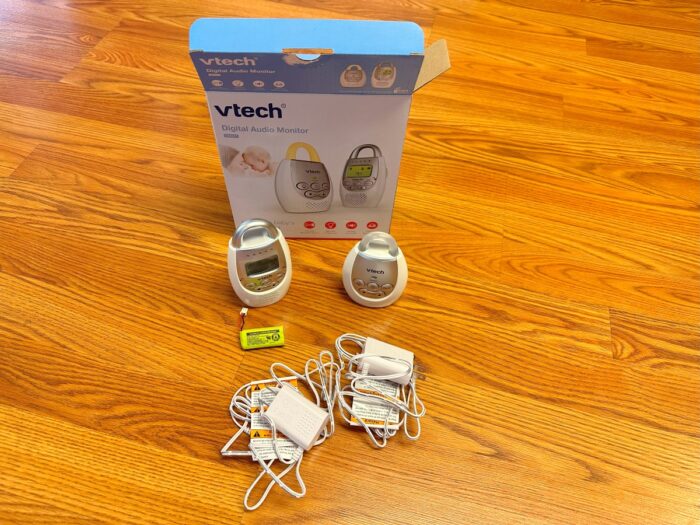 The vtech dm221 audio baby monitor on the floor with box