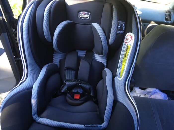 chico car seat installed in back seat of car, forward facing